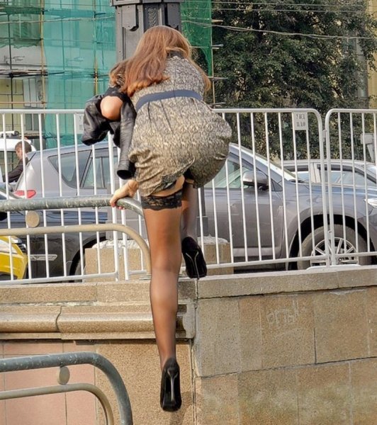 Девушка перелезает через забор