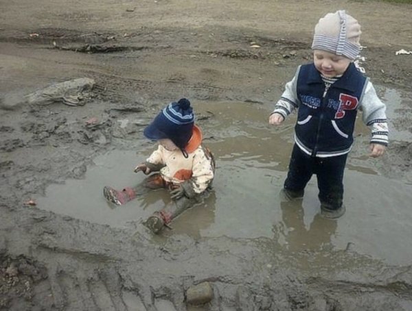 Ребенок сидит в луже