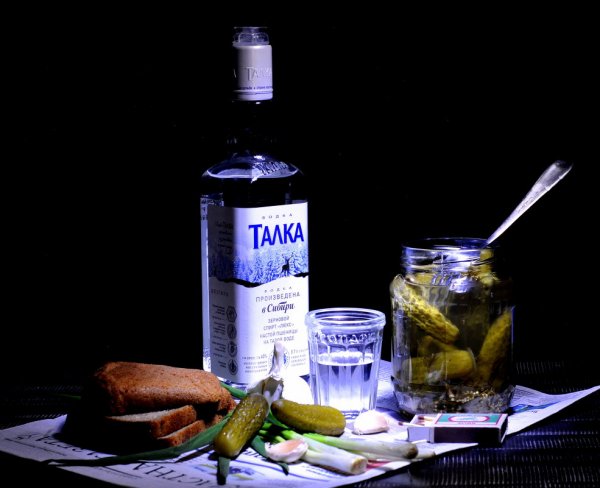 Бутылка водки на столе с закуской