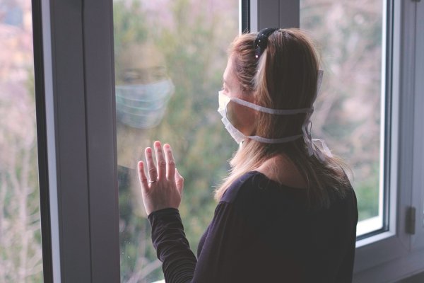 Девушка в маске у окна