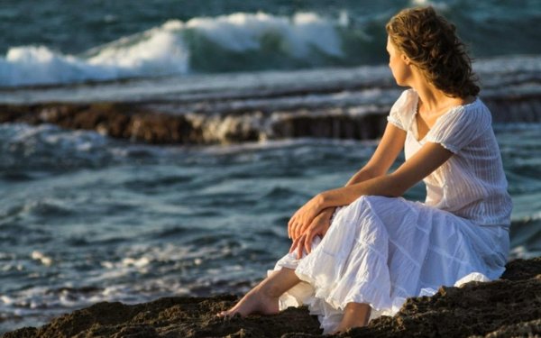 Девушка у моря грустит