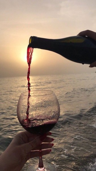 Бокал в руке на море