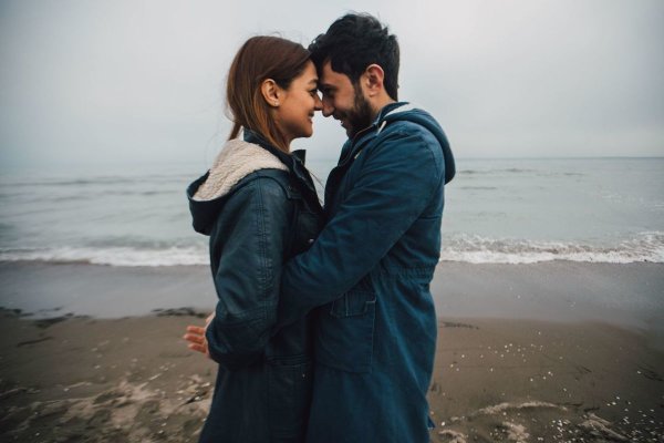 Обнимает девушку