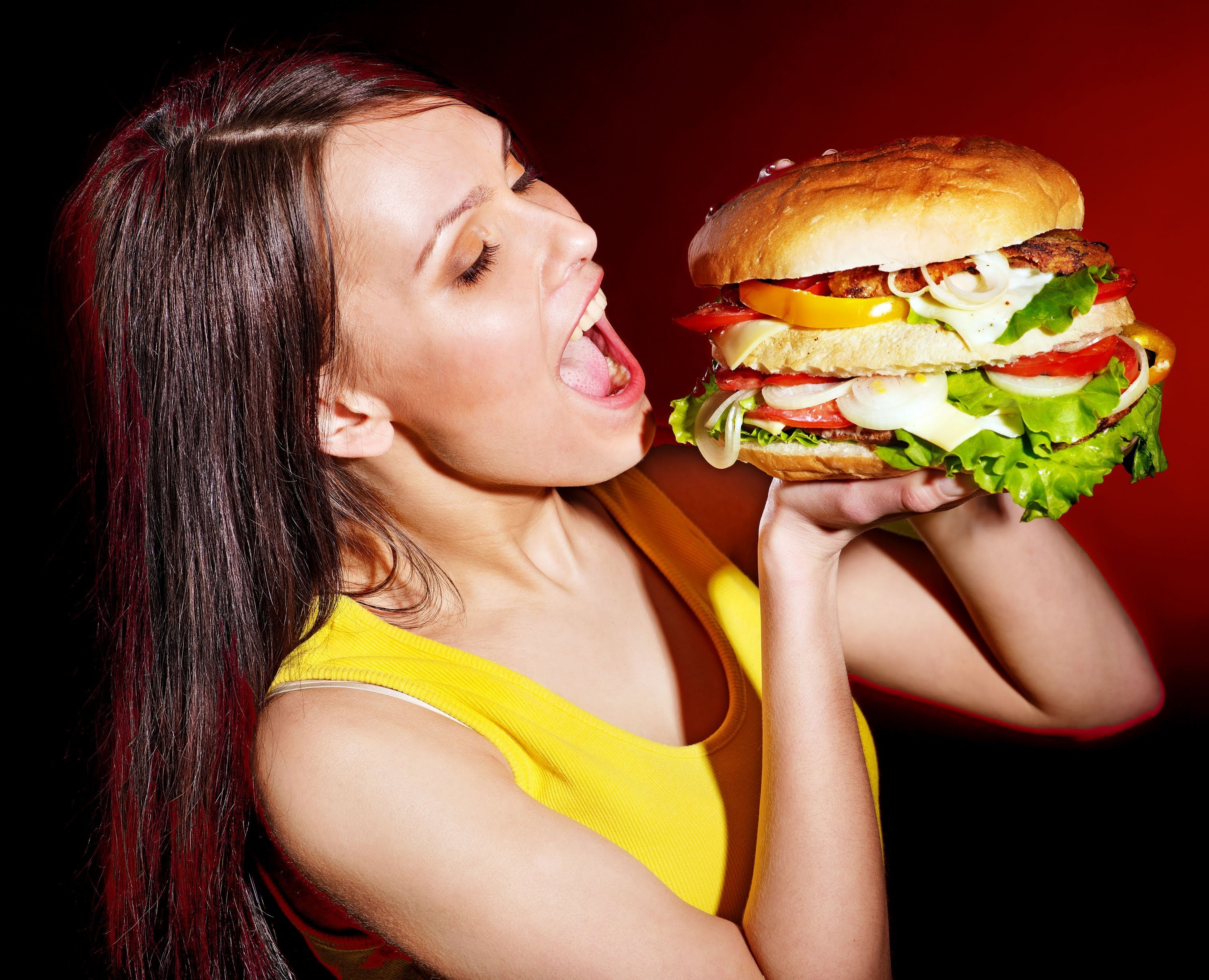 She eats meat. Девушка с гамбургером. Девушка ест гамбургер. Человек ест бургер. Человек ест гамбургер.